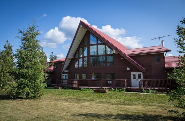 A large, red, A-frame building with multiple windows and a porch.