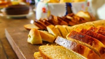 Una mesa de madera con diferentes alimentos, incluyendo pan y pasteles.
