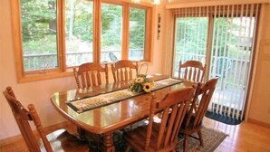 A dining room with a wooden table, six chairs, and a chandelier. - Serenity (Davis)