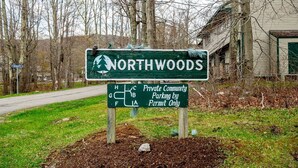 Un panneau indiquant le stationnement réservé aux résidents de la communauté privée de Northwoods, précisant qu’il s’agit d’une zone de stationnement accessible uniquement sur présentation d’un permis.
