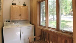 A laundry room with wooden cabinets and a washing machine.