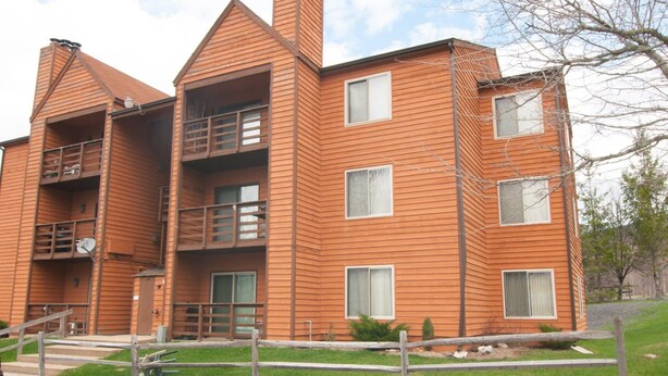 A multi-story wooden building with balconies and windows. - Herzwoods D304 (Davis)