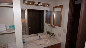 A bathroom with a sink, mirror, and towel rack. - Herzwoods D304 (Davis)