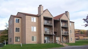 Un immeuble à plusieurs étages, doté d’une façade symétrique, de balcons à chaque étage et d’une cheminée centrale.
