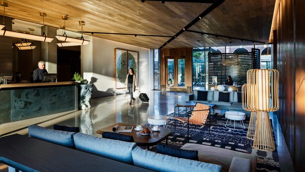 A spacious lobby with a wooden ceiling, a reception desk, seating areas, and large windows offering views of the outdoors. - Hotel San Luis Obispo (San Luis Obispo)