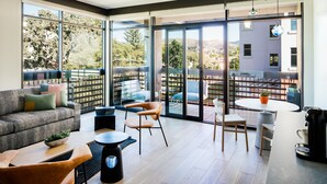 A modern living room with a sofa, chairs, a coffee machine, and a dining area with a table and chairs. - Hotel San Luis Obispo (San Luis Obispo)