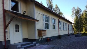 Une maison à deux étages avec un porche à l’avant, une porte et une fenêtre.