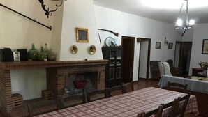 Comedor con mantel a cuadros, chimenea de ladrillo y candelabro.
