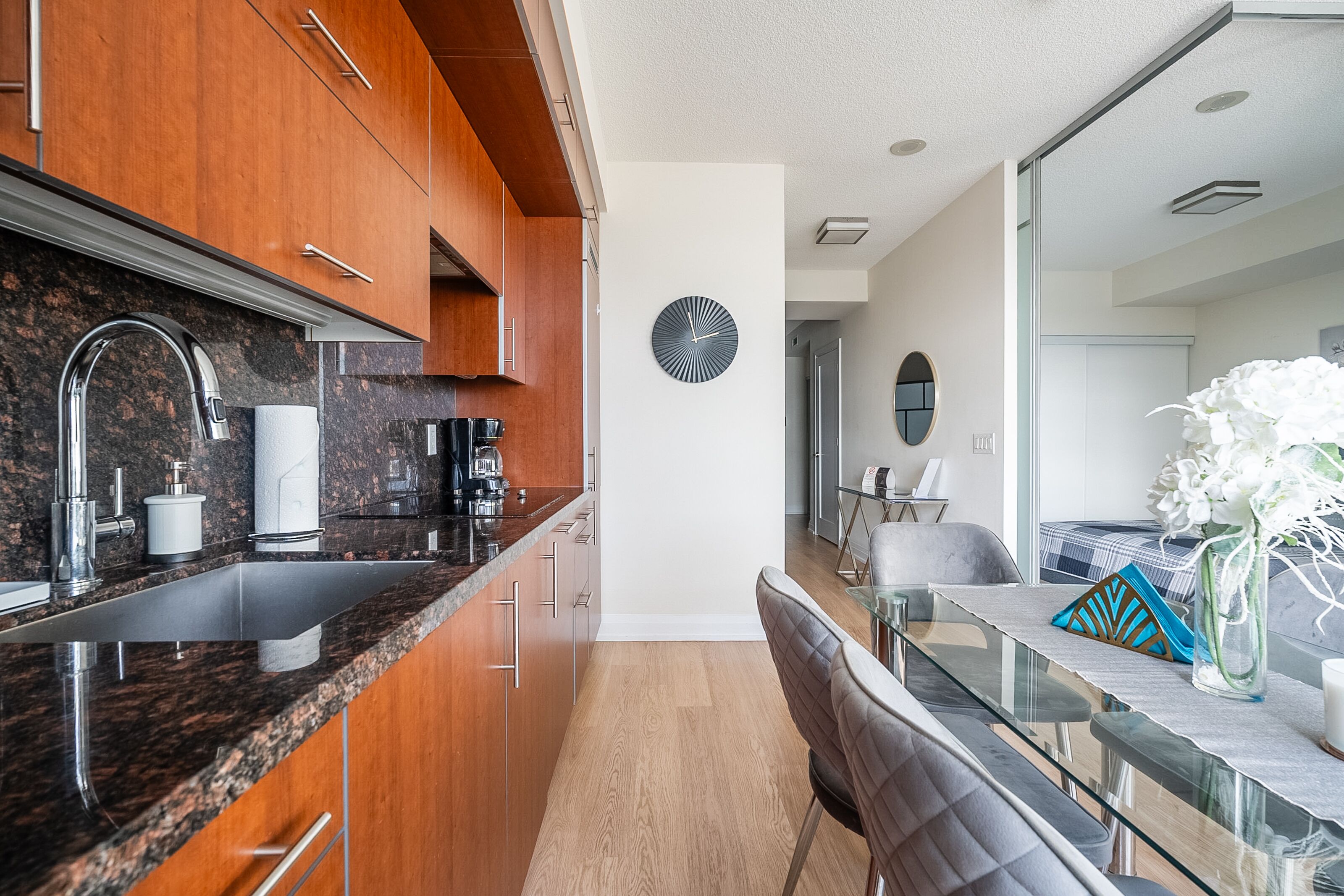 A modern kitchen with granite countertops, stainless steel appliances, and wooden cabinets.