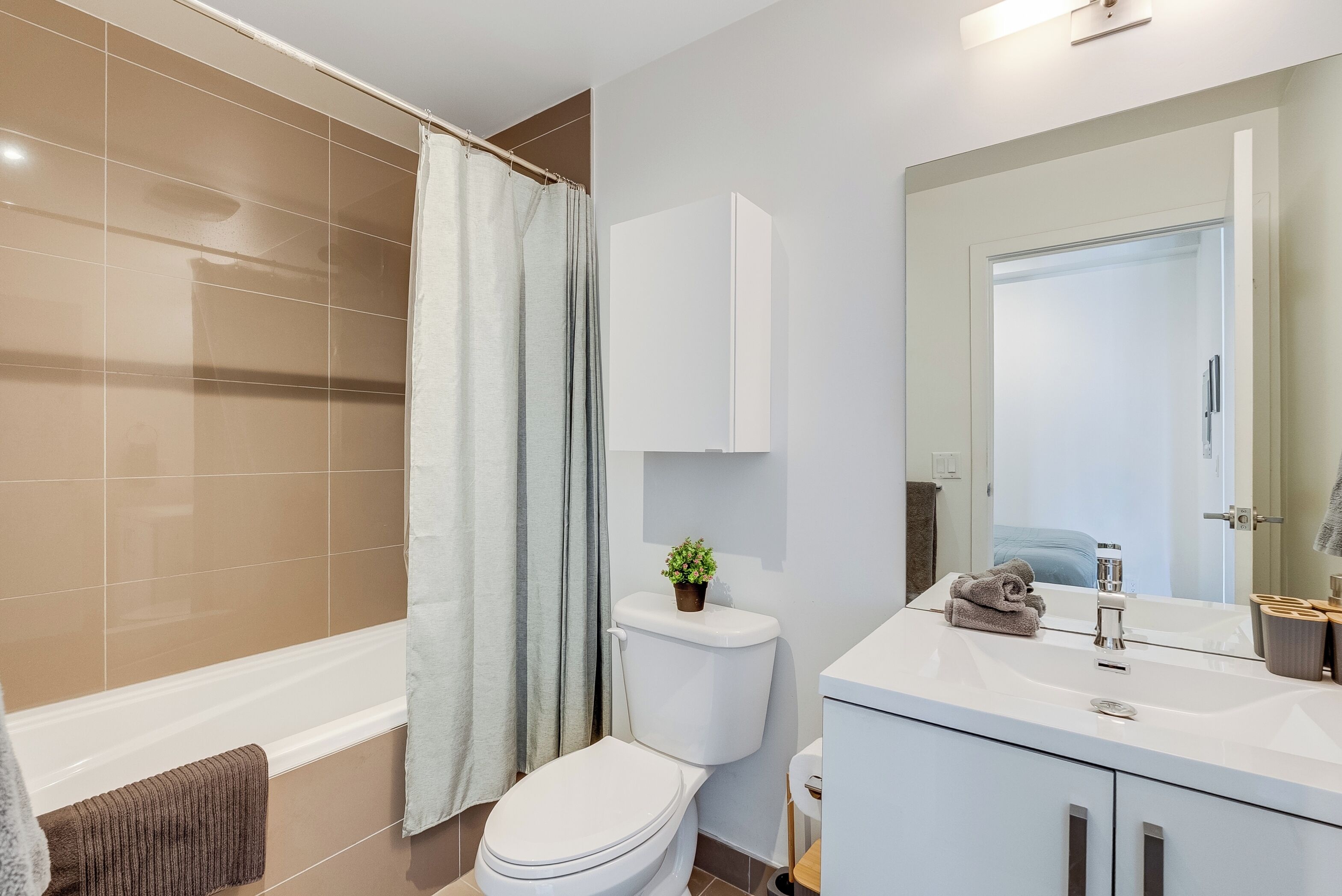 A modern bathroom with a bathtub, toilet, and vanity.