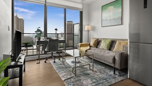 Ein modernes Wohnzimmer mit Sofa, Couchtisch und Fernseher.