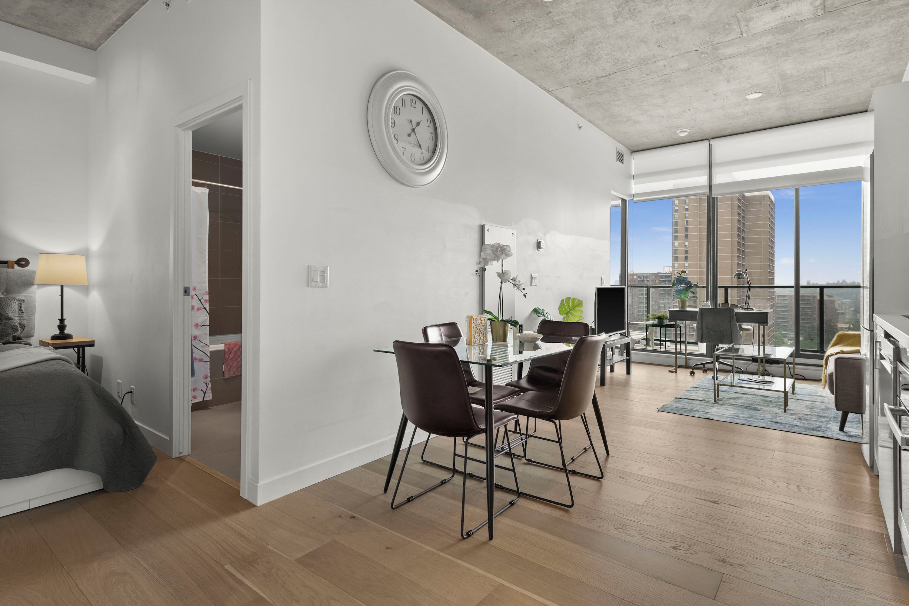 Een modern appartement met een eetgedeelte, een woonkamer en een balkon met uitzicht over de stad.