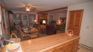 A spacious kitchen with wooden cabinets, a dining area with a table and chairs, and a living room with a fireplace.