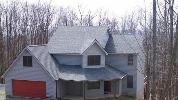 A two-story house with a red garage door, a covered front porch, and a sloped roof. - Hart`s Horn (Davis)