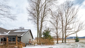 A two-story building with a wooden porch and a snow-covered landscape. - Coire Taigh (Davis)