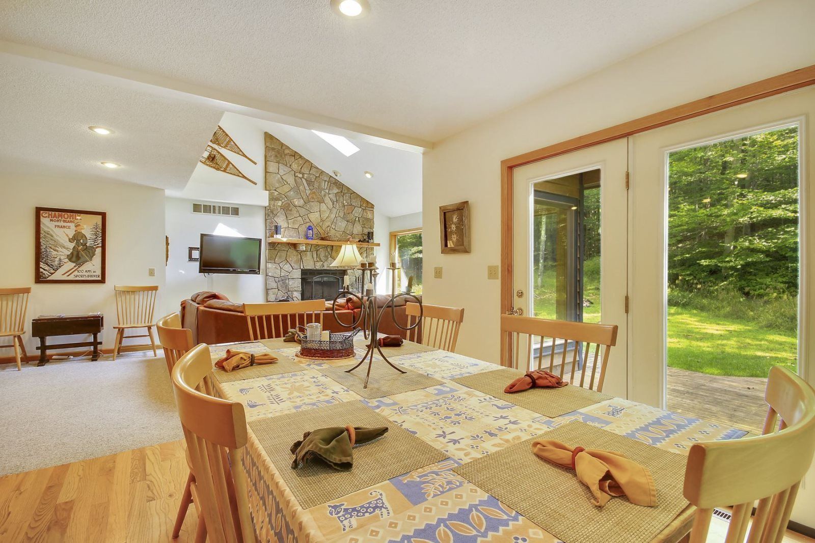 A cozy dining area with a large table, chairs, and a fireplace.