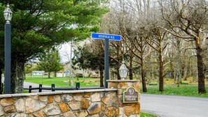 A stone wall with a 'Deerfield Village' sign and a street sign for 'Deerfield VLG'. - Deerfield Village 106 (Davis)