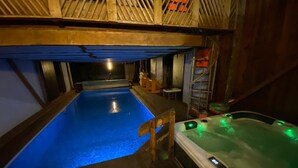 En interiör med träinredning, en swimmingpool och ett bubbelbad.