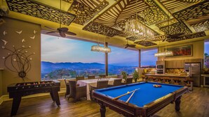 A spacious room with a pool table, foosball table, and a view of mountains. - La Toscana Hills (Atenas)