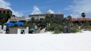 A beachside hotel with a large building, palm trees, and a sandy beach. - Marco Beach Ocean Resort 610: Private 1 Bedroom condo; New Tile,TV's (Marco Island)