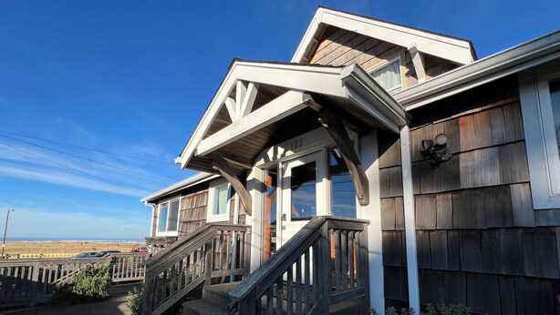 A two-story house with a wooden exterior, a front porch with a wooden railing, and a visible number '122' on the house. - Absolutely fantastic, charming retreat with ocean views! (Seaside)