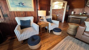 A cozy living room with striped armchairs, a wooden coffee table, and a rug. - Absolutely fantastic, charming retreat with ocean views! (Seaside)
