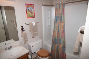 A bathroom with a toilet, sink, and shower curtain. - Beaver Ridge 260 (Davis)