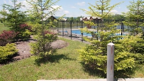A fenced outdoor area with a pool and a building in the background. - Aspen Village 35 (Davis)