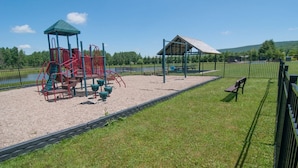 A playground with a climbing structure and a small shelter. - Aspen Village 35 (Davis)
