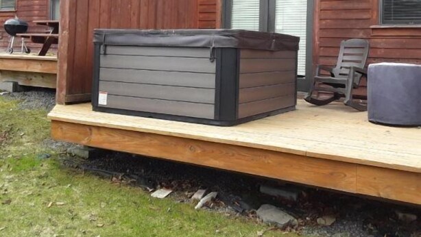 A wooden deck with a hot tub, a grill, and outdoor furniture. - Aspen Village 35 (Davis)