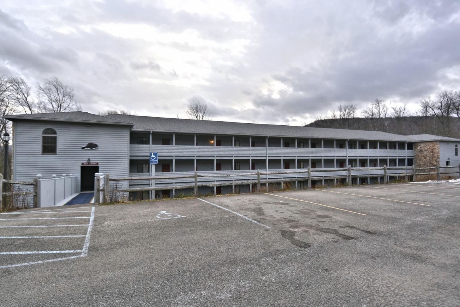 A multi-story building with a central entrance and a parking lot.