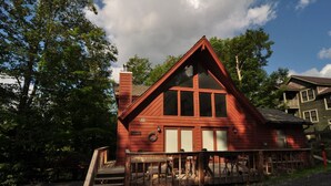 A red cabin with a steep roof, large windows, and a wooden deck. - Bear`s Den - Northface (Davis)