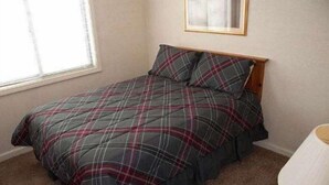 A bedroom with a bed, a window, and a lamp. - Beaver Ridge 116 (Davis)