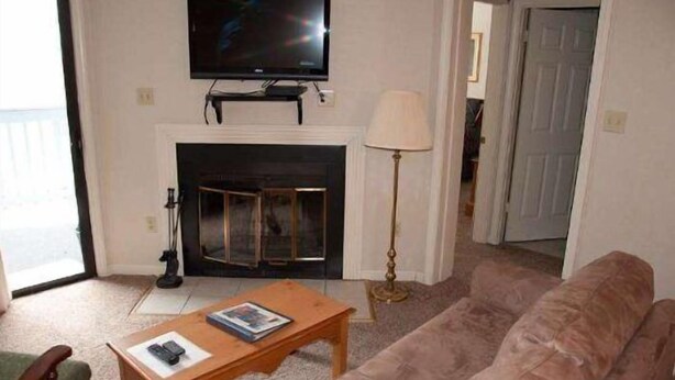 A living room with a television, fireplace, sofa, and a lamp. - Beaver Ridge 116 (Davis)