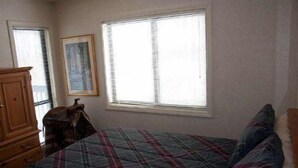 A bedroom with a bed, a dresser, a window with blinds, and a framed picture on the wall. - Beaver Ridge 116 (Davis)