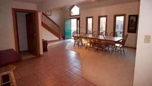 A spacious dining area with a high ceiling and a staircase leading to an upper level. - Almost Heaven (Davis)
