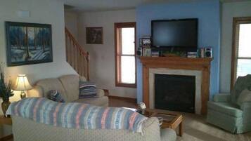 Casa | Sala de estar | Televisión de pantalla plana, chimenea, reproductor de DVD y futbolito