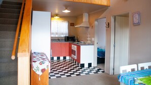 Une cuisine de taille réduite avec un carrelage à motifs, un four à micro-ondes et un évier.