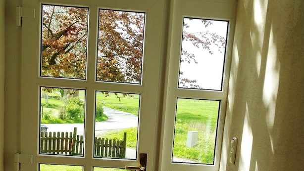 Una puerta con varias ventanas que dan a un jardín.