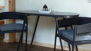 Un comedor con una mesa y sillas, un estante con vajilla y un pequeño objeto decorativo sobre la mesa.