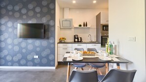 Eine moderne Küche mit Flachbildfernseher, Mikrowelle und Kaffeemaschine.