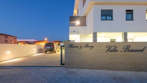 Eine moderne Villa mit einem Schild, auf dem 'Villa Barolo' steht, und einem Auto auf der Auffahrt.