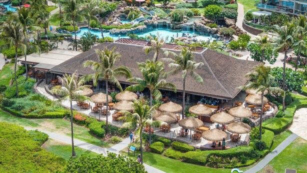 A resort with a pool area, outdoor seating, and lush landscaping.