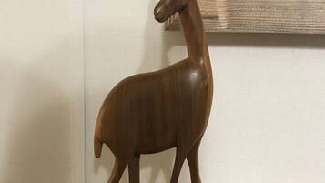 A wooden deer sculpture on a wooden base.