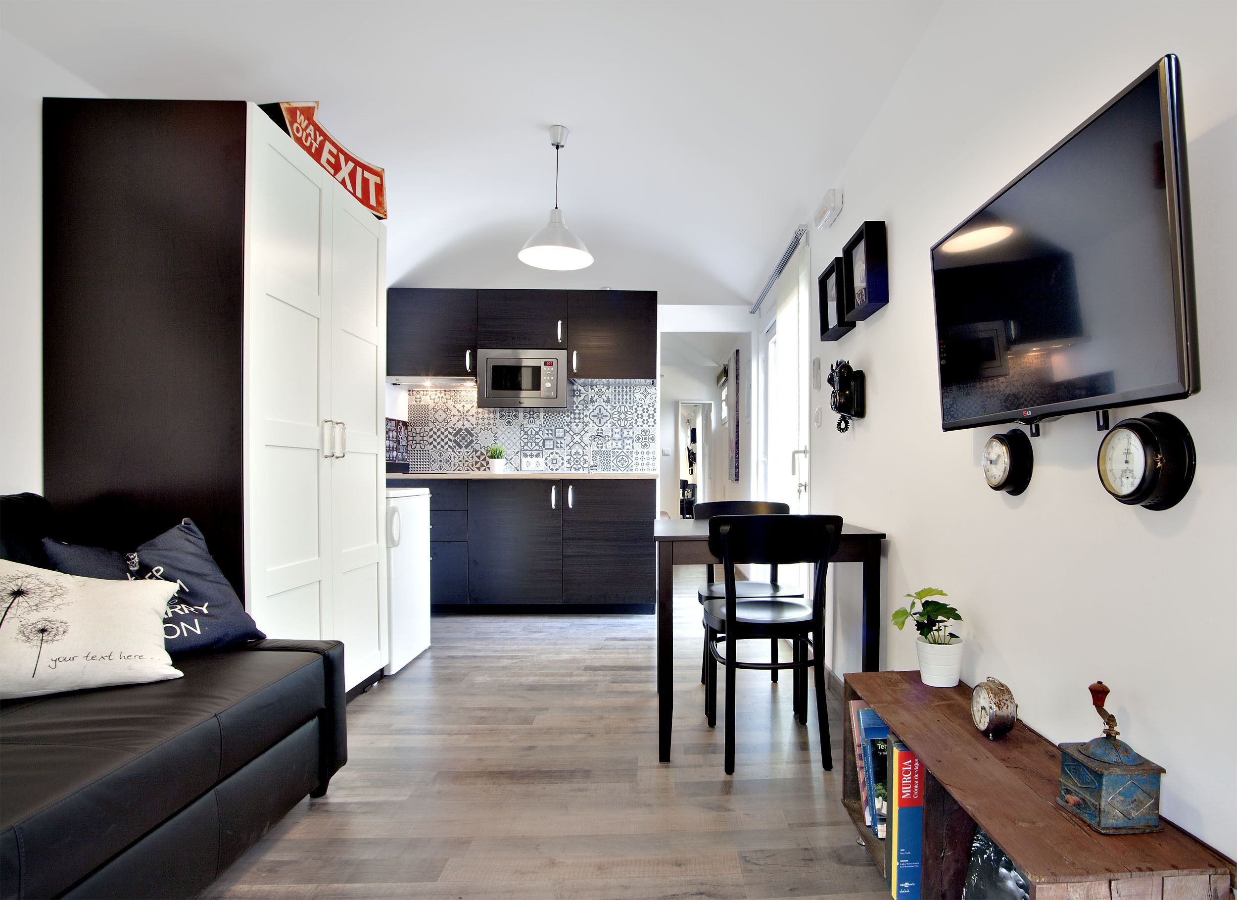 Cocina moderna con armarios oscuros, un microondas y un salpicadero con diseño.