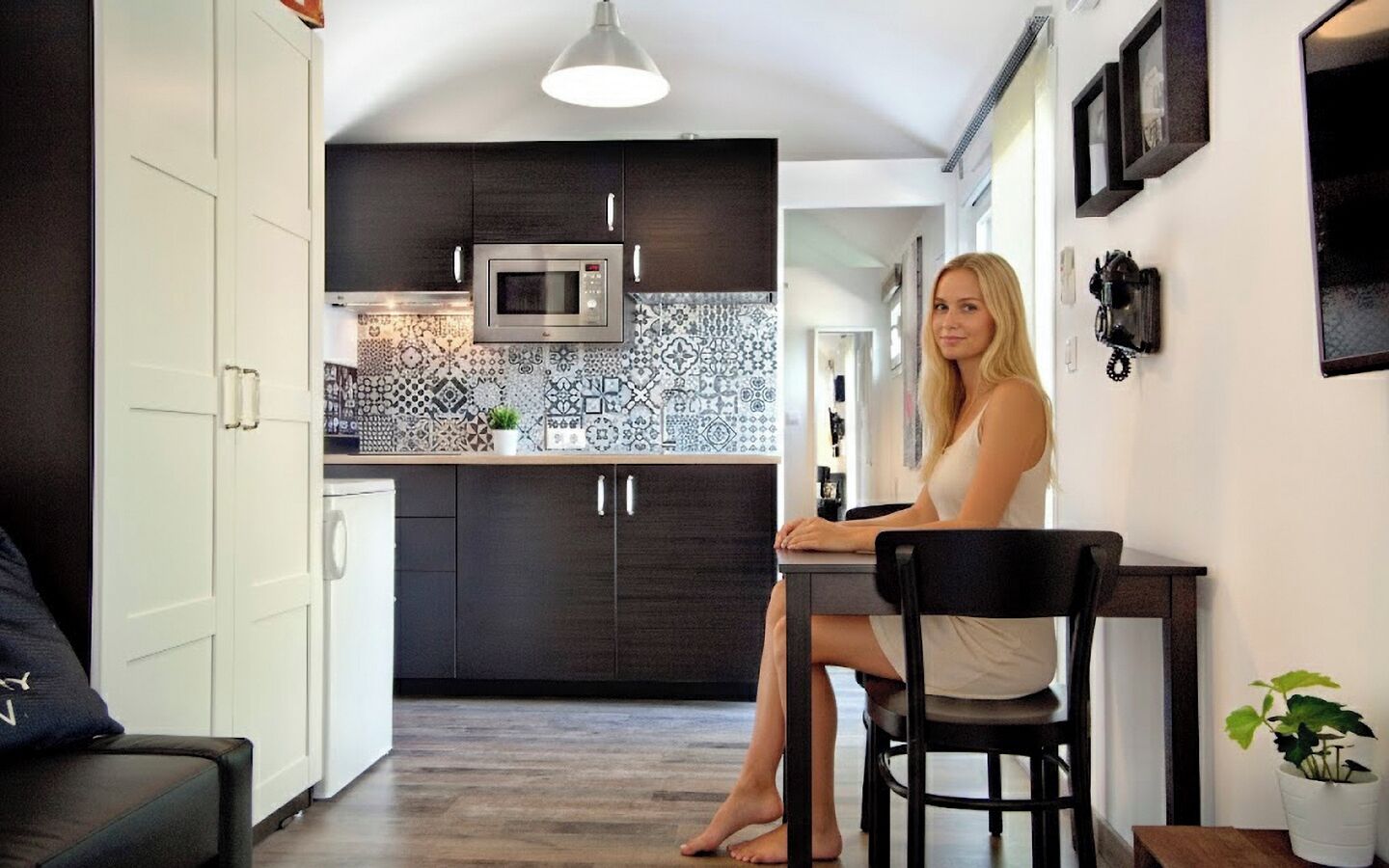 Una cocina moderna con armarios oscuros, un microondas y un salpicadero con diseño.