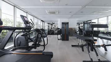 A gym with treadmills, exercise bikes, and weight machines.