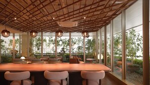 Een modern interieur met een groot houten plafond, grote ramen en een centraal gelegen bar met zitplaatsen.