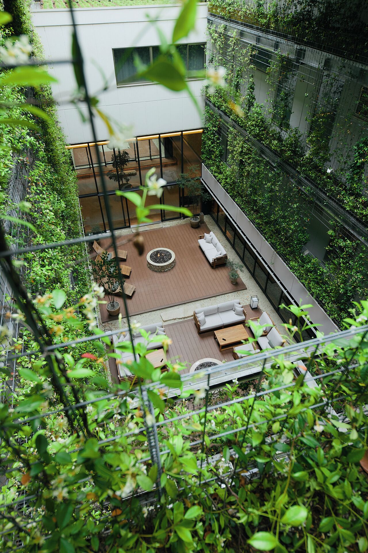 Un jardin sur le toit, agrémenté d’un foyer, d’un espace salon et de plantes en pot.