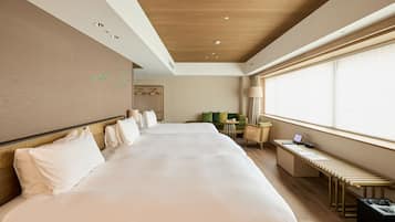 A hotel room with a large bed, a seating area, and a window with blinds.